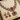 Ornate necklace and earrings with red stones on a beige cushion